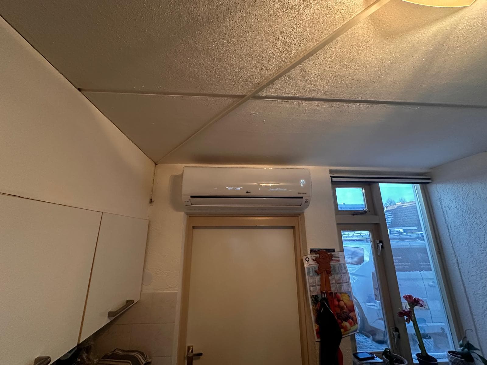Airco-binnendeel boven een deur in een keuken
