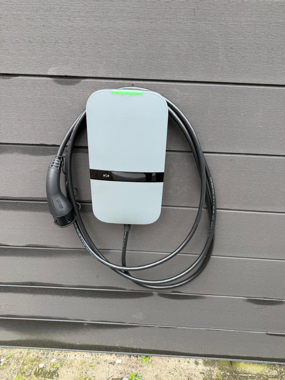 Laadpaal met kabel aan de gevel van een woning