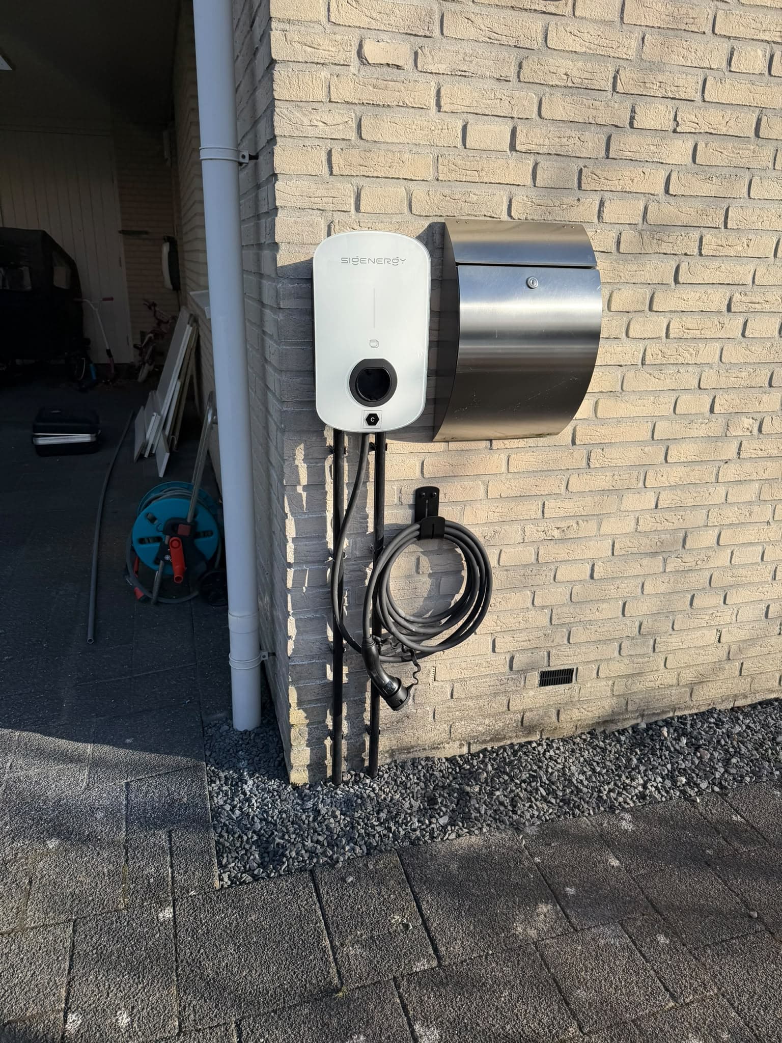Sigenergy-laadpaal aan een bakstenen gevel